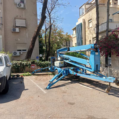 מנוף כחול לחיתוך גיזום עצים בחניה