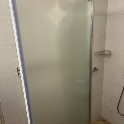 דלת מקלחת מזכוכית בחדר אמבטיה נקי