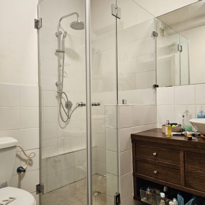 מקלחון זכוכית עם ראש מקלחת מתכתי ומדף קטן