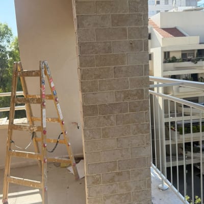 עמוד אבן עם סולם במרפסת בניין