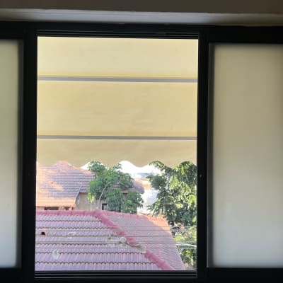 סוכך צהוב מעל גגות רעפים אדומים ועצים ירוקים