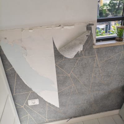 קיר עם טפט מתקלף ליד חלון