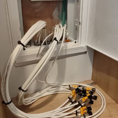 כבלים לבנים מחוברים לשקעי רשת בארון תקשורת