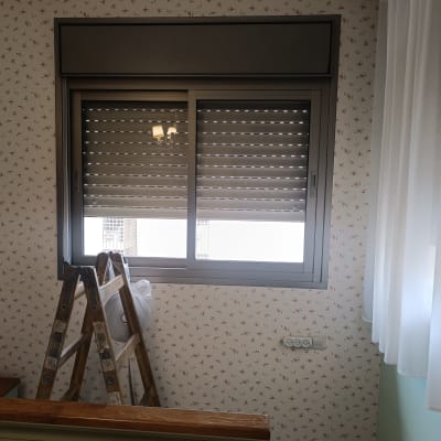 תריסים סגורים עם סולם ליד חלון בחדר