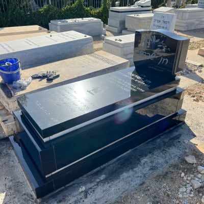 מצבות שחורות ולבנות עם כתובות בעברית בבית קברות