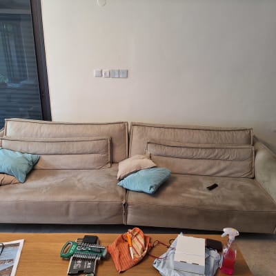 ספה עם כריות וכלי ניקוי על שולחן