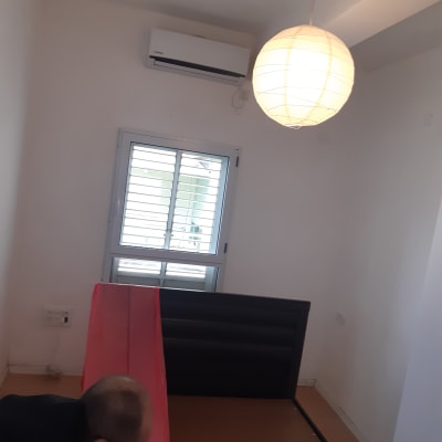חדר עם קיר לבן ומנורה תלויה