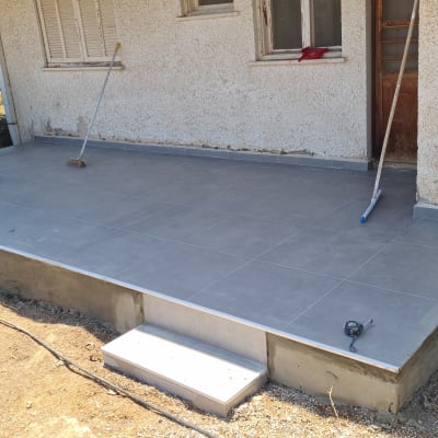 מרפסת מרוצפת עם כלים לשיפוץ ועובד בשטח