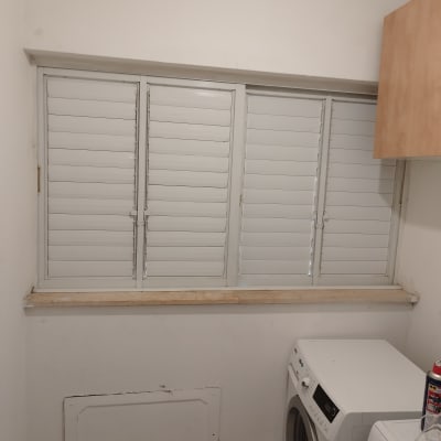 תריסים לבנים סגורים על חלון גדול