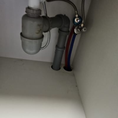 צינורות מתחת לכיור עם חיבורים ואביזרי אינסטלציה