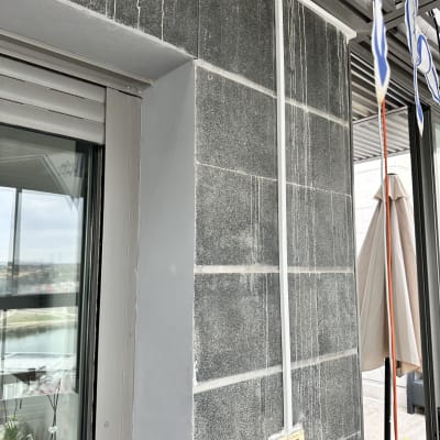 כבל חשמל לבן מחובר לשקע על קיר חיצוני