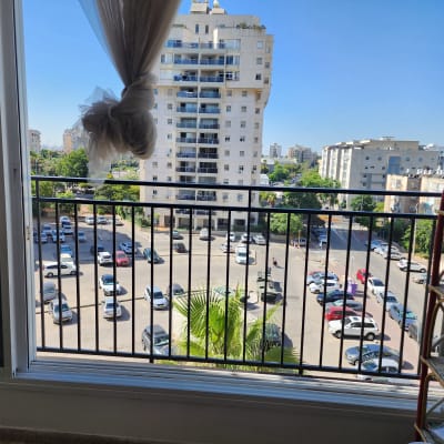 חלון פתוח עם מסגרת מתכת ונוף עירוני