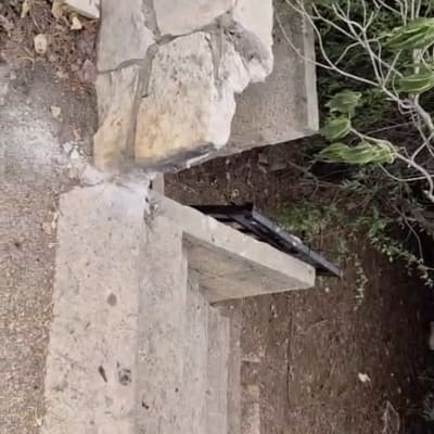 מעקה מתכת שחור מותקן לצד מדרגות אבן בגינה