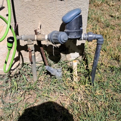 צינור ירוק מחובר לברז בגינה