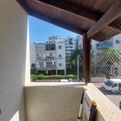 רשת נגד יונים מותקנת במרפסת עם סולם.