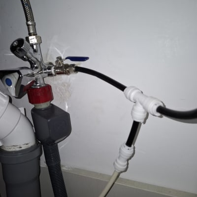 צינורות חיבור עם ברזים מתכתיים מתחת לכיור