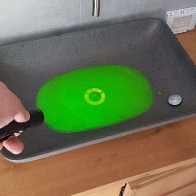 כיור עם מים ירוקים, יד מחזיקה פנס