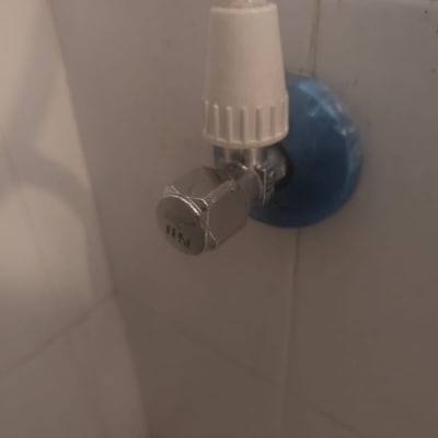 ברז מים מותקן על קיר עם חיבור כחול