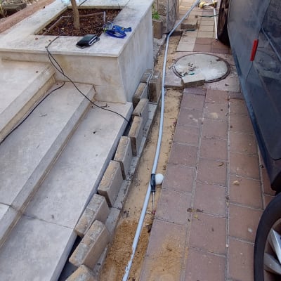 כבלים וכלי עבודה ליד מדרכה וחניה