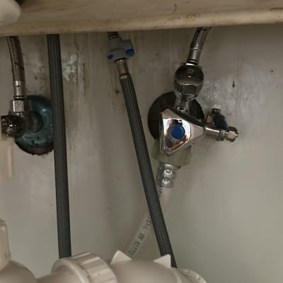 צנרת מתחת לכיור עם חיבורים וברזים