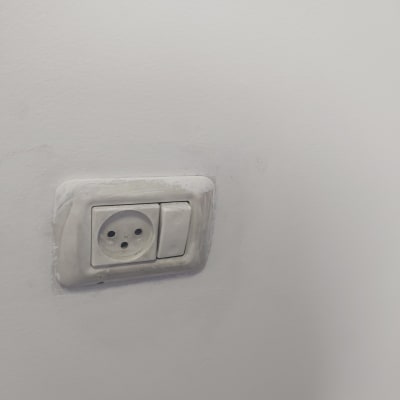 שקע חשמל ומתג על קיר לבן