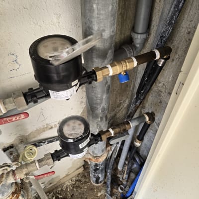 מד מים וצינורות מתכת עם ברזים