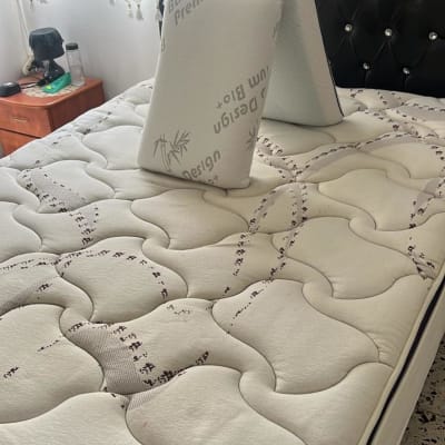 מיטה עם מזרן וכריות בחדר שינה מואר