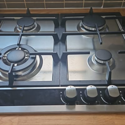 כיריים גז עם ארבעה מבערים על משטח עץ במטבח