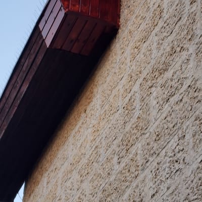 מרזב על קיר אבן עם קוצים למניעת ציפורים