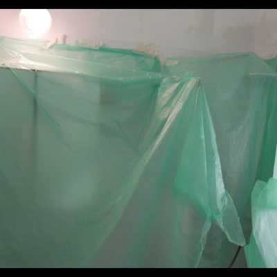 יריעות פלסטיק ירוקות מכסות אזור לצביעת קירות