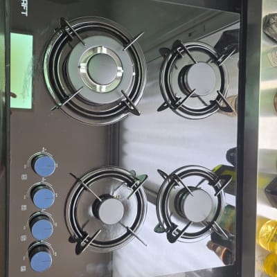 כיריים גז שחורות עם ארבעה מבערים וכפתורים כחולים