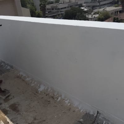 ציפוי ואיטום בחומר לבן של קיר מעקה בגג שטוח