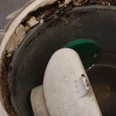 נזילה סביב מכסה פלסטיק לבן עם סימני רטיבות