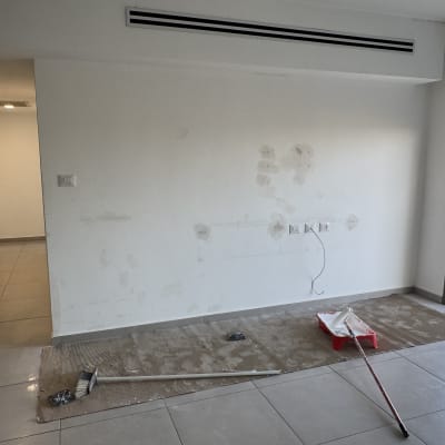 קיר עם תיקוני צבע וכלי עבודה לצביעה