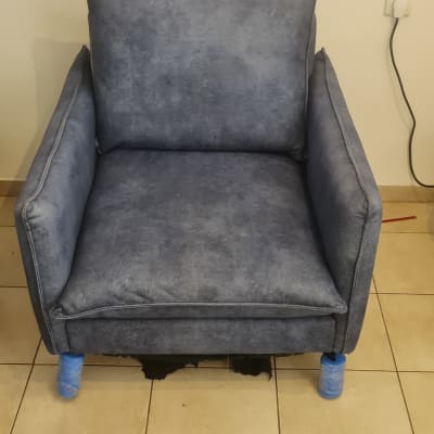 כורסה כחולה על רצפת אריחים עם רגליים עטופות