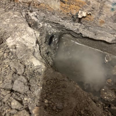 מים דולפים מתוך קיר עם סדקים ועפר