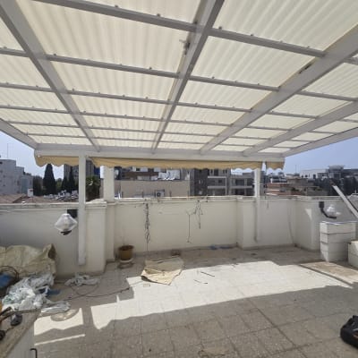 פרגולה מאלומיניום על גג עם ריצוף אבן