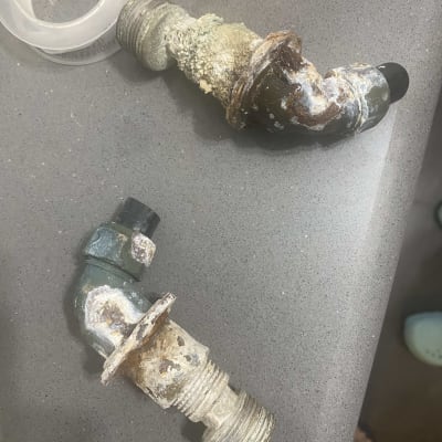 שני צינורות חלודים עם קורוזיה על משטח אפור