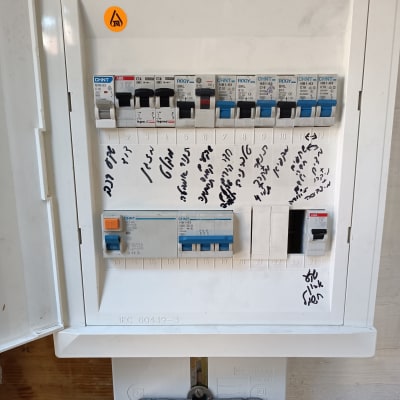 לוח חשמל עם מפסקים וכיתוב בכתב יד