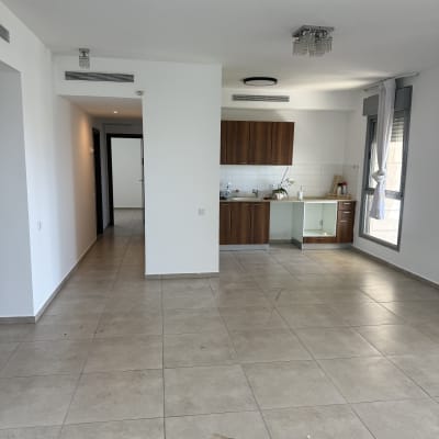 דירה ריקה עם רצפת אריחים ומטבח קטן