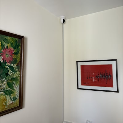 מצלמת אבטחה מותקנת בפינת חדר עם תמונות על הקיר