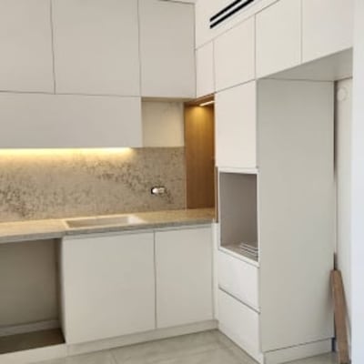 מטבח חדש עם ארונות לבנים ותאורה נסתרת