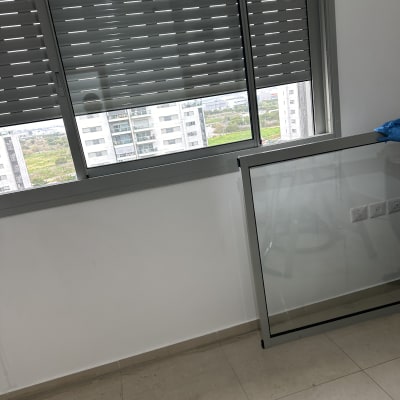 חלון עם תריסים סגורים, רצפה רטובה, כפפה כחולה