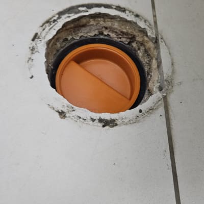 פתח ניקוז עם מכסה כתום ברצפה