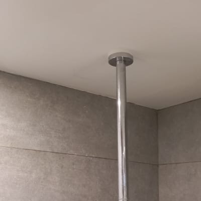 צינור מתכת מחובר לתקרה בחדר אמבטיה