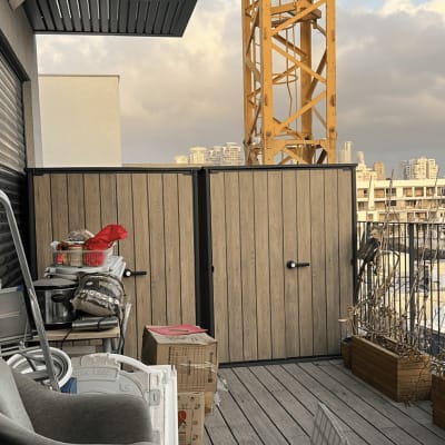 מרפסת עם ציוד וכלים, רקע של מנוף ובניינים