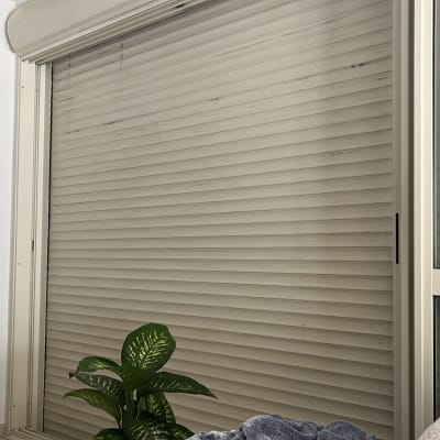 תריסים סגורים על חלון זכוכית עם מסגרת לבנה