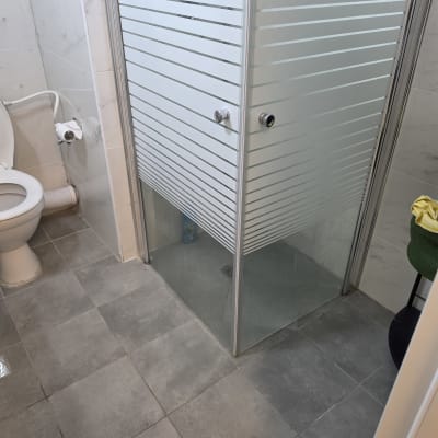 מקלחון פינתי מזכוכית עם דלתות הזזה בדוגמת פסים חלביים