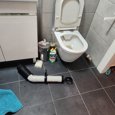 כלי עבודה לניקוי שירותים על רצפת חדר אמבטיה