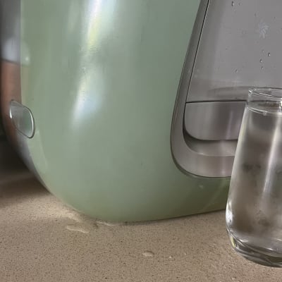 מכונת מים וכוס על משטח מטבח